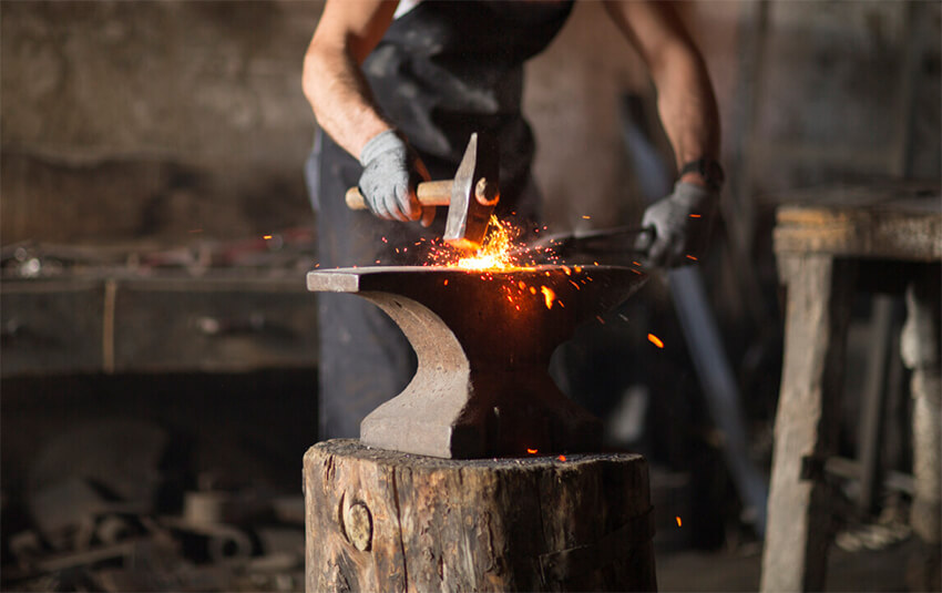 Craftsman with hammer and anvil to symbolize resiliency