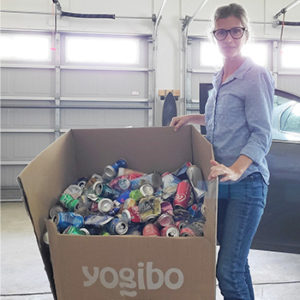 Woman with a large box of aluminum cans for recycling